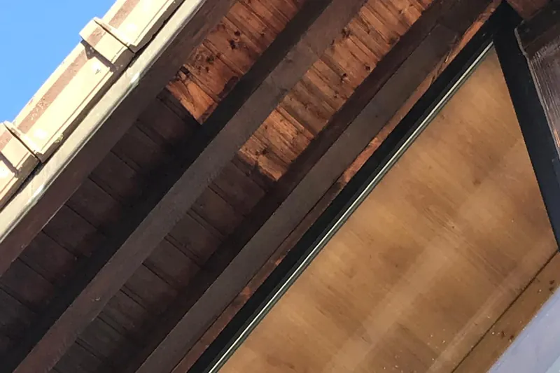 Débord de toit en bois pendant l'application de la lasure