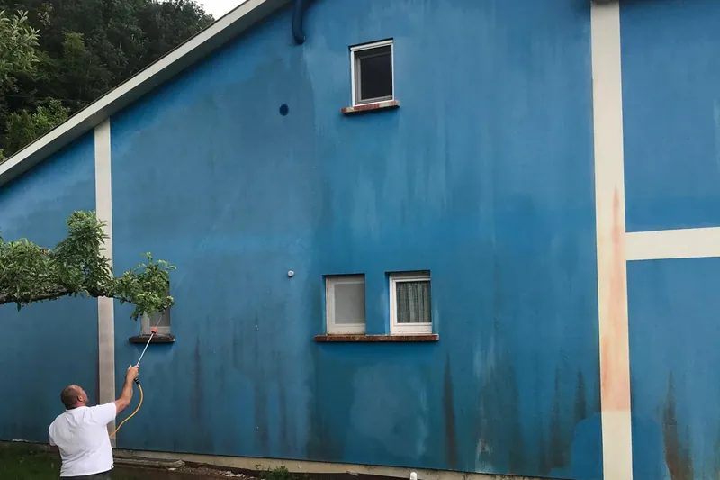 Lavage d'une façade bleue avant sa remise en peinture