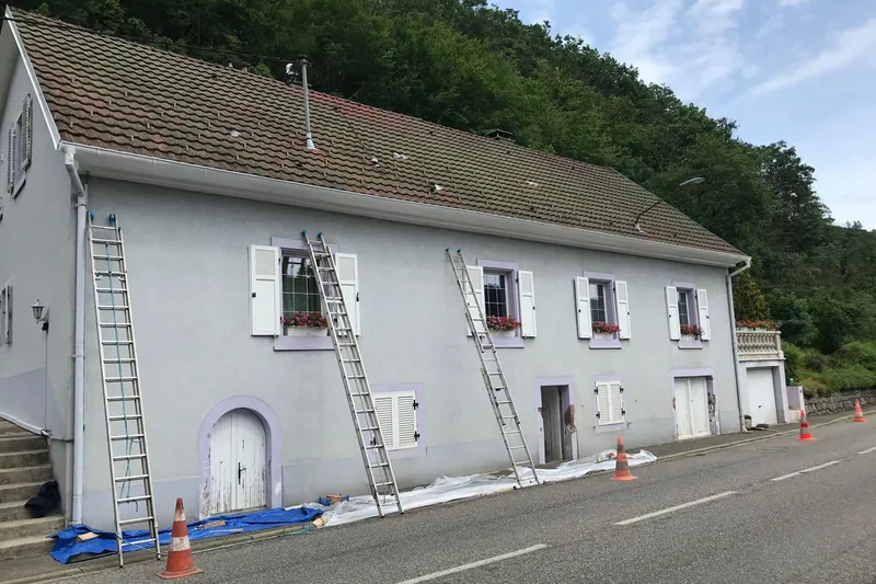 Grande maison de village en cours de ravalement, échelles et balisage côté route