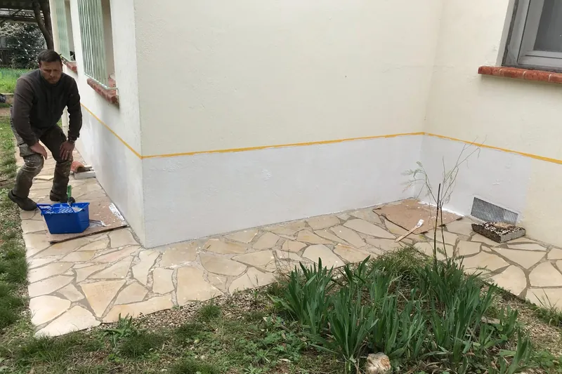 Mise en peinture d'un soubassement de façade, limite marquée à l'adhésif