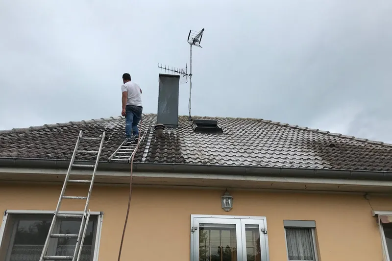 Intervention sur une toiture en tuiles béton, échelles en façade